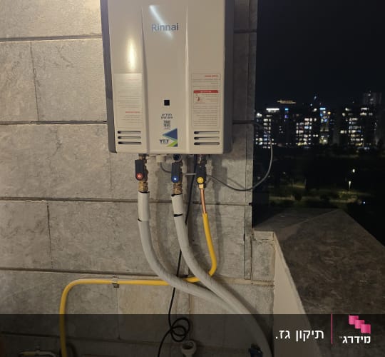 מחמם מים מותקן על קיר עם צינורות חיבורים